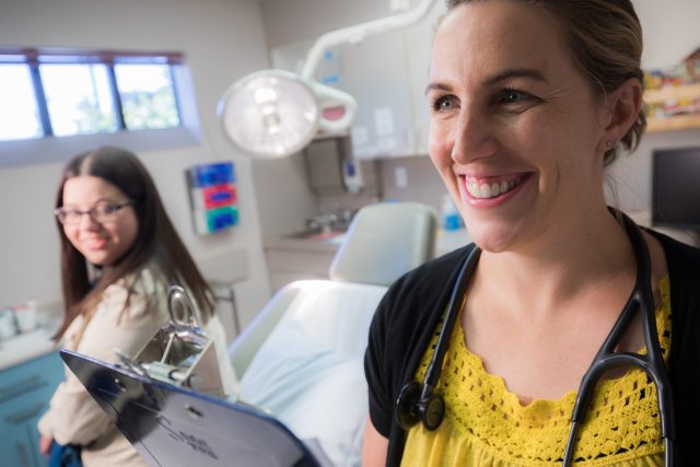 A patient and doctor smile in an exam room