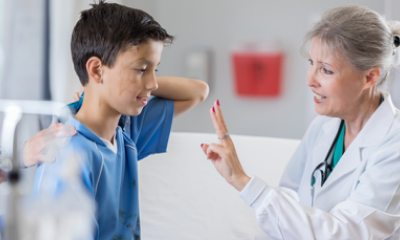 Young soccer player and female physician during exam for concussion