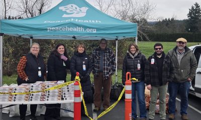 Peacehealth caregivers under peacehealth tent providing thanksgiving baskets