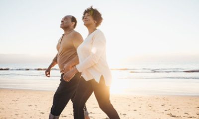 Black man and woman walk on the beach