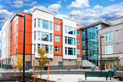 Orange and white condo building against a blue sky background