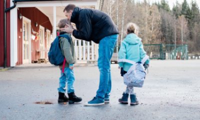 A dad says good-bye to young children at school