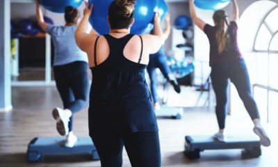 People exercising in class with steps and large rubber balls