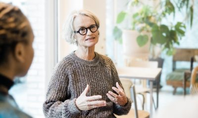 Two women speaking in a professional setting.