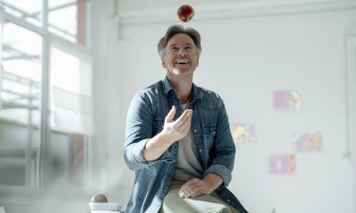 Man sits on table and catches an apple