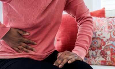 Close-up of Black woman's hand pressed against side of stomach