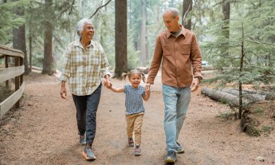 Grandmother, young child and grandfather walking on a wooded trail in the Pacific Northwest USA