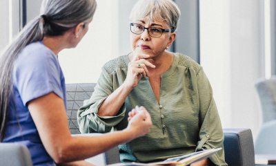 A senior adult woman listens carefully as a female doctor explains a concept to her.