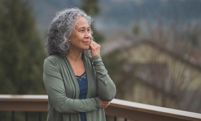 Woman looks thoughtful while standing outside on an overcast day