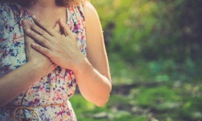 woman holds hand to heart