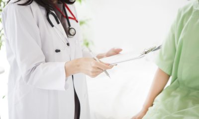 A provider holds a chart while talking with a patient