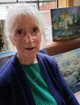 Sherry McCalden in front of some of her paintings