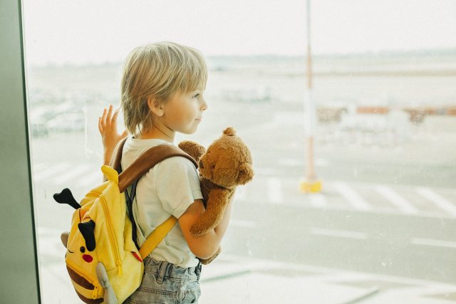 Young child looks out window at airport